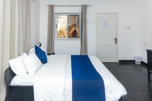 a bedroom with a large bed with blue and white pillows at Tills Beach Resort in Fetta