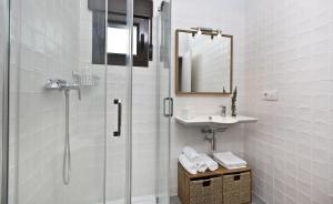 Un baño con ducha, lavabo y espejo. en Senda del Cabrerizo, en Albarracín