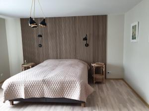 a bedroom with a bed and a striped wall at Crow's nest in Grobiņa