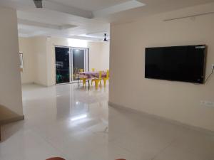 a living room with a flat screen tv on a wall at Feel Like Home Rushikonda in Visakhapatnam
