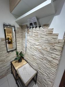 a stone wall in a room with a table and a mirror at MILET style and spacy 2 room apartment with AC in Bratislava Nivy in Nivy