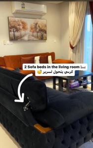um sofá-cama numa sala de estar com uma mesa em Sifah Ocean Breeze Villa em Mascate