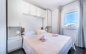 1 dormitorio con 2 animales de peluche en una cama en Amazing Apartment In Vrsi With Kitchen, en Vrsi