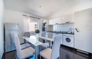 cocina con mesa y lavadora en Amazing Apartment In Vrsi With Kitchen, en Vrsi