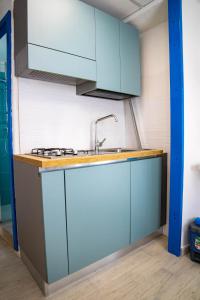科馬基奧的住宿－Residence Eden，厨房配有蓝色橱柜和水槽