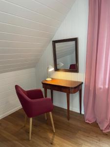 a table with a mirror and a chair in a room at Ferienhaus Jolufelu , Urlaub zwischen See und Golfplatz in Göhren-Lebbin