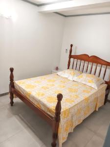 uma cama num quarto branco com uma moldura de madeira em Appartement d'une chambre avec terrasse amenagee a Le Vauclin a 3 km de la plage em Le Vauclin