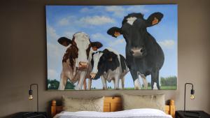un dipinto di tre mucche su un muro sopra un letto di Ferienwohnung König Ludwig - Chiemgau Karte a Inzell