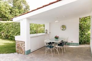 a white patio with a table and chairs at Villa Camilla by MyVillaCollection in Ischia