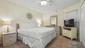 a bedroom with a bed and a flat screen tv at Cabana Club 206, Beachfront,Gulf view, King Bed, private beach in Destin
