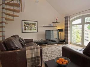 a living room with a couch and a television at Discovery - Luxury Cosy Country Escape in Grantham
