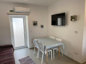 a dining room with a table and chairs and a television at Palheiro do Rei in Fátima