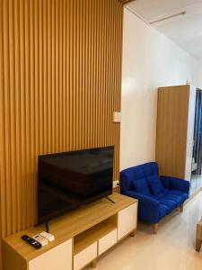 a living room with a television and a blue couch at D Luckycharm staycation in Tagaytay