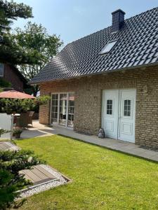 a brick house with a white door and a yard at Ferienhaus Jolufelu , Urlaub zwischen See und Golfplatz in Göhren-Lebbin