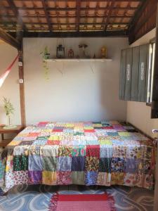 Cama en habitación con colcha colorida en Hospedagem Casinha do Solar, en Soure
