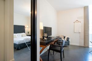 a bedroom with a bed and a desk with a computer at Hotel Palazzo Cavalieri in Syracuse
