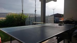 a ping pong table in front of a balcony with a view at בגג העמק - וילה in HaZore‘im