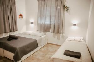 a bedroom with two beds and a window at בגג העמק - וילה in HaZore‘im +91 photos