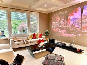 una sala de estar con sofá y una pintura en la pared en Langley 半地下室独立出入温馨卧房-桐花草堂, en Langley