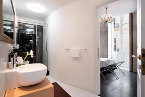 a white bathroom with a sink and a shower at Hotel Palazzo Cavalieri in Siracusa
