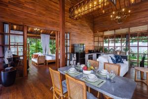 ウブドにある1BRV Cozy Villa with Amazing Rice Paddy Viewのテーブルのあるダイニングルームとリビングルーム
