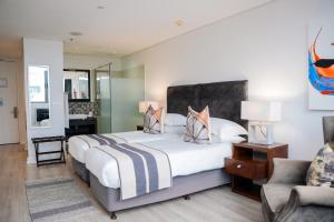 a bedroom with a large bed and a chair at Newkings Boutique Hotel in Cape Town