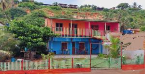 ein farbenfrohes Haus mit einem Zaun davor in der Unterkunft Chalé Panulirus in Icapuí