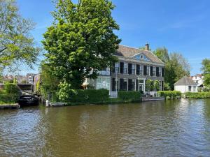 ein Haus in einer überfluteten Straße mit einem Fluss in der Unterkunft Tuinhuis aan het water in Voorburg