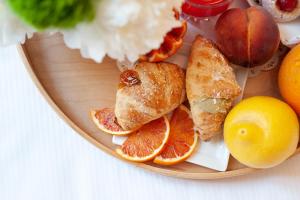 einen Teller mit Orangen und anderen Früchten in der Unterkunft Hotel Palazzo Cavalieri in Syrakus