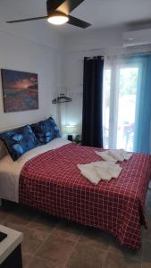 een slaapkamer met een bed met een rode deken en een raam bij Faros Sea View - Sifnos in Faros +51 foto's