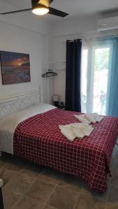 een slaapkamer met een bed met een rood-witte deken bij Faros Sea View - Sifnos in Faros