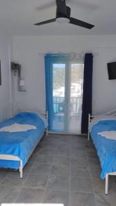 a bedroom with two beds and a ceiling fan at Faros Sea View - Sifnos in Faros +39 photos