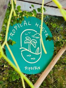 a green sign with a picture of a beach at Tropical Hostel in Pipa