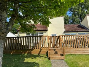 a wooden fence in front of a house at Frankie's Holiday Lodge in Gunnislake