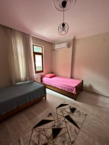 特拉布宗的住宿－Trabzon Meydanın Göbeğinde Kiralık Daire，一间卧室设有两张带粉色床单的床和窗户。