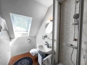 biała łazienka z umywalką i prysznicem w obiekcie Chalet MOOS w mieście Todtmoos