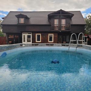 una casa con piscina frente a una casa en Morrison Apartments, en Miercurea-Ciuc