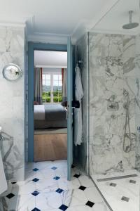 uma casa de banho com um chuveiro e uma porta de vidro em Althoff Hotel Villa Belrose em Saint-Tropez