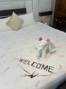 a bed with a hello kitty stuffed elephant on it at Baansuan Suksangob Farm Stay in Trang