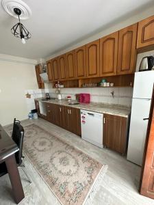 a kitchen with wooden cabinets and a white refrigerator at Trabzon Meydanın Göbeğinde Kiralık Daire in Trabzon