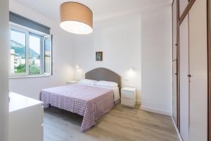 una camera da letto bianca con un letto e una finestra di Attico Maria Pia a Sant'Agnello