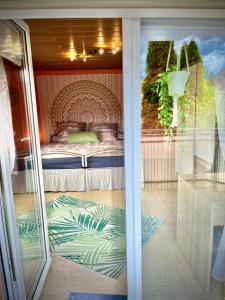 Blick auf ein Schlafzimmer mit einem Bett durch eine Glastür in der Unterkunft neXt doOr Donau Gästezimmer und Suite in Wurmlingen
