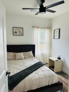 a bedroom with a bed with a ceiling fan at HTX Urban Oasis -Mins to Downtown, NRG, & Med Ctr! in Houston