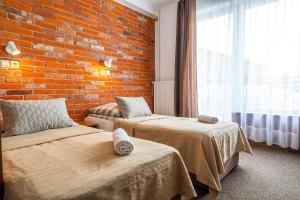 una camera con due letti e un muro di mattoni di MAX Apartamenty - Pokoje - Domki - Restauracja - Basen a Mielno