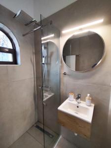 a bathroom with a sink and a shower with a mirror at Tony's Garden House in Lefkimmi +32 photos