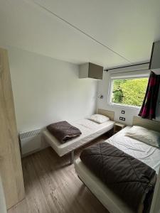 a small room with two beds and a window at Camping Le Panoramic in Binic +76 photos