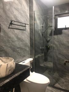 a bathroom with a toilet and a glass shower at Tuần Châu HQT in Ha Long