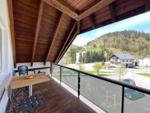 a room with a balcony with a table and chairs at Chalet MOOS in Todtmoos
