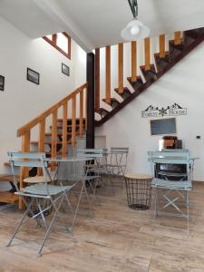 een eetkamer met een tafel en stoelen en een trap bij Forese House in Rivisondoli