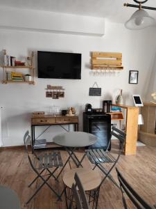 a living room with a table and chairs and a tv at Forese House in Rivisondoli